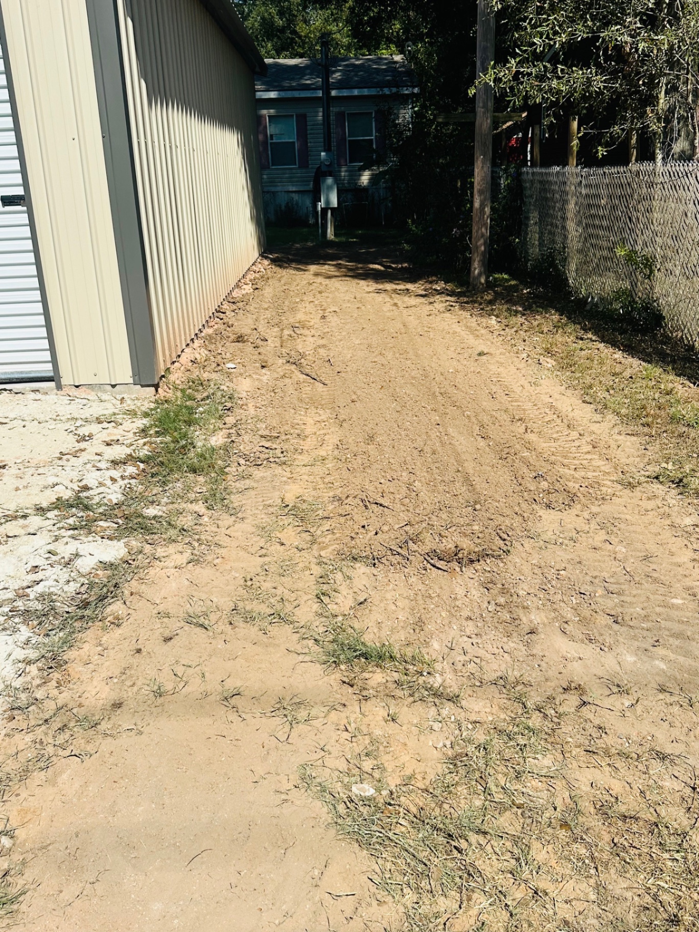Narrow side-yard drive graded and shaped for drainage