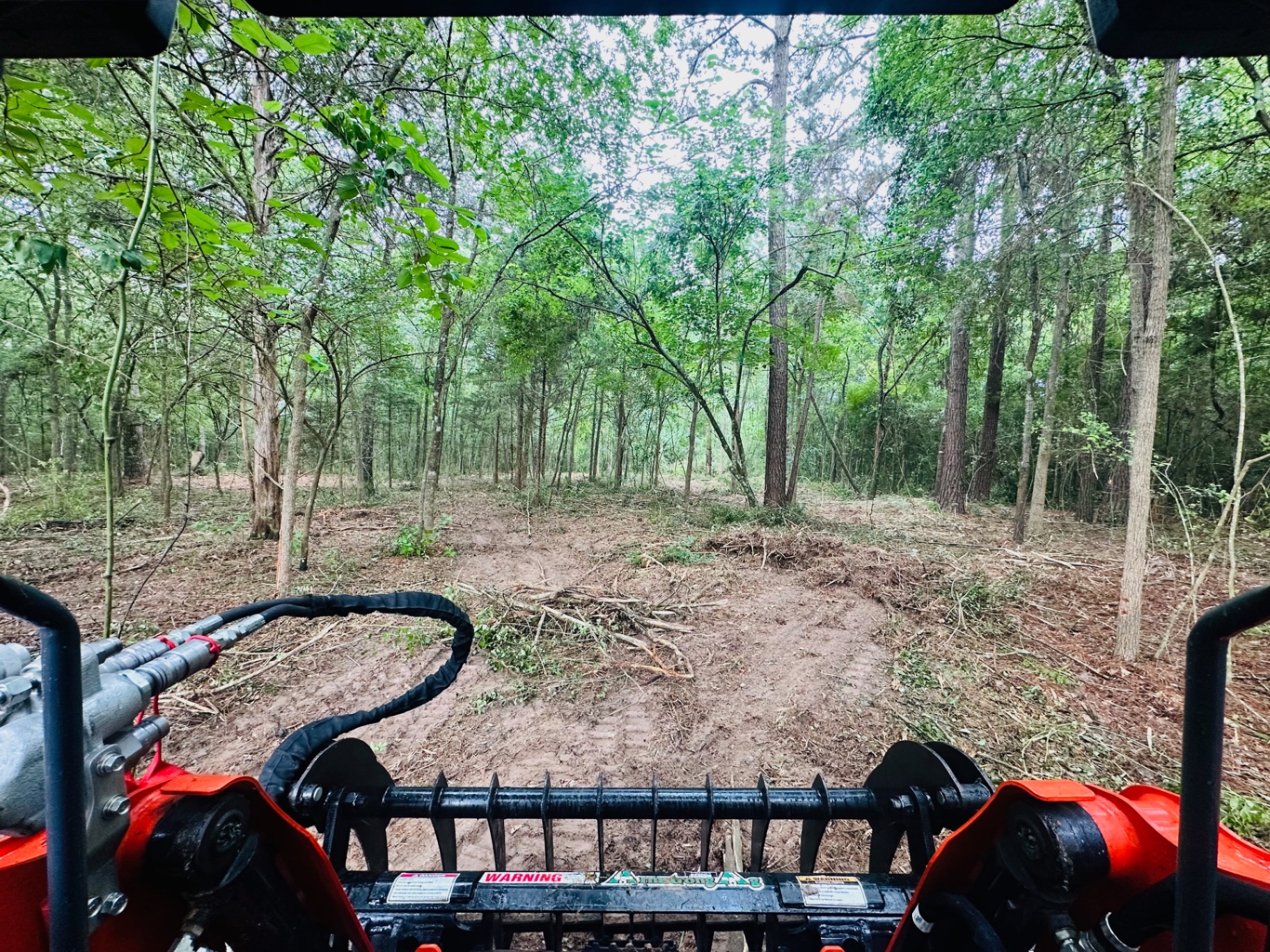 Underbrushing thick woods from the skid-steer cab